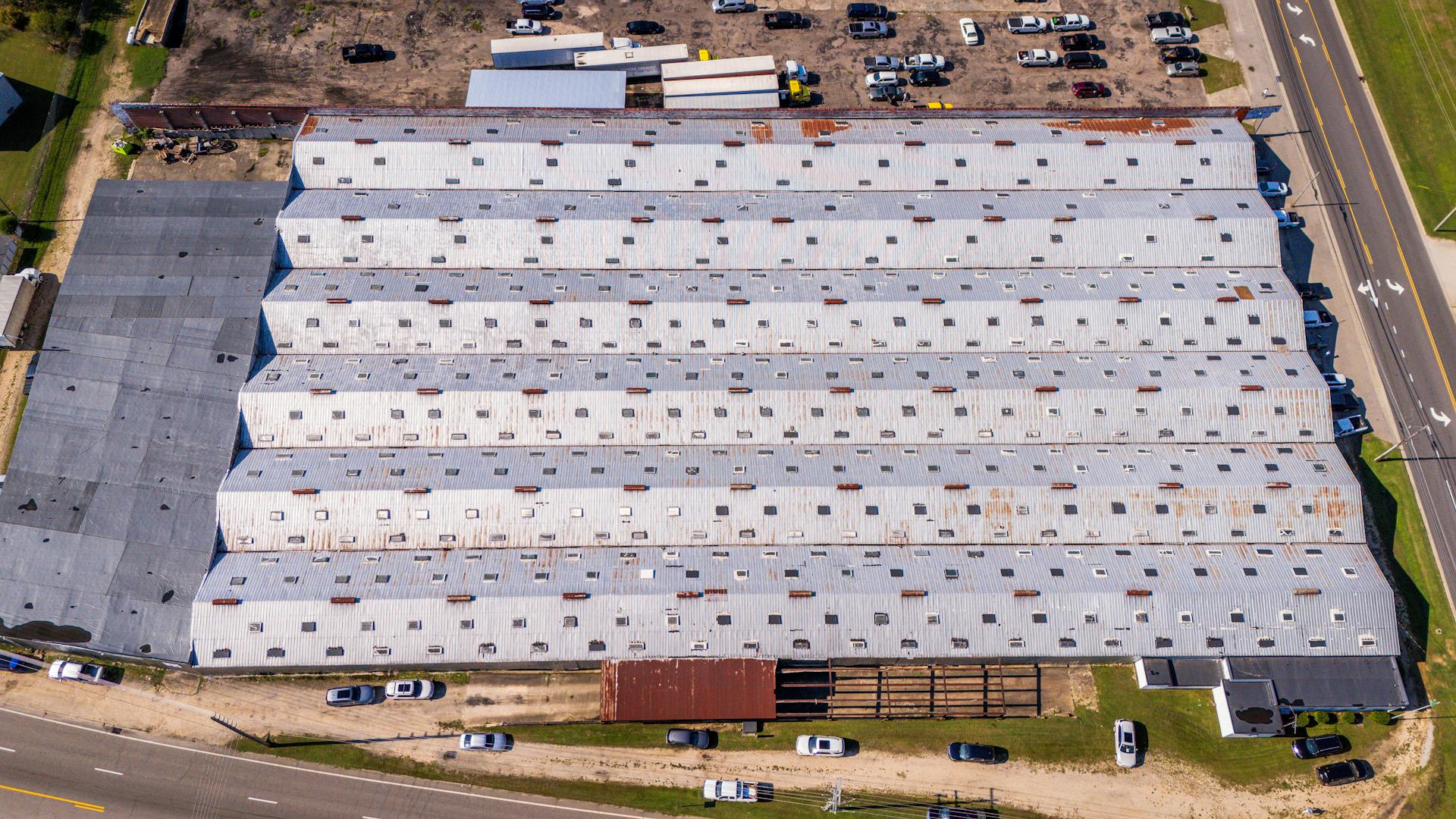 An aerial view of a large warehouse with a roof