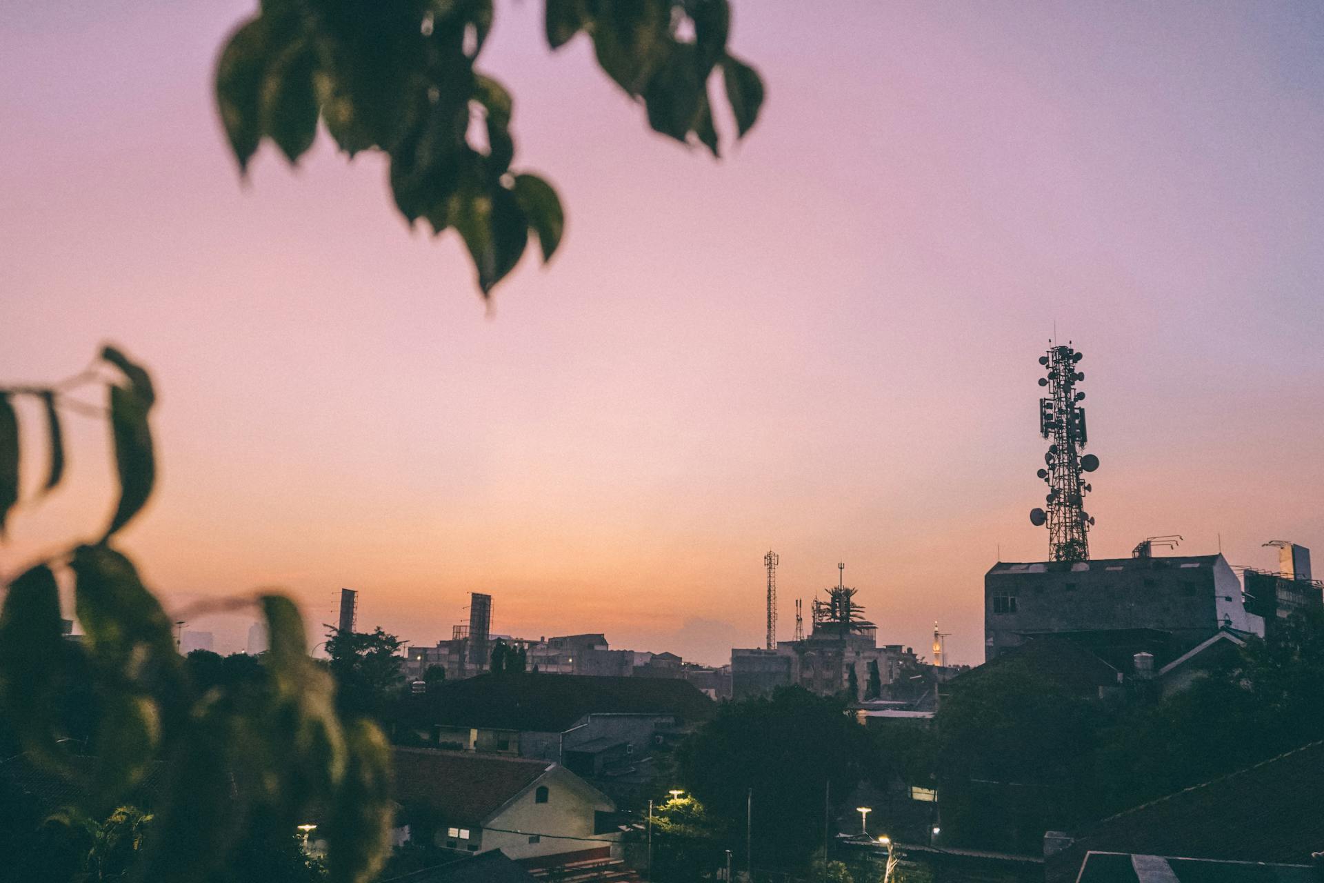 Serene view of Jakarta at dusk with silhouetted buildings and a pastel sky.