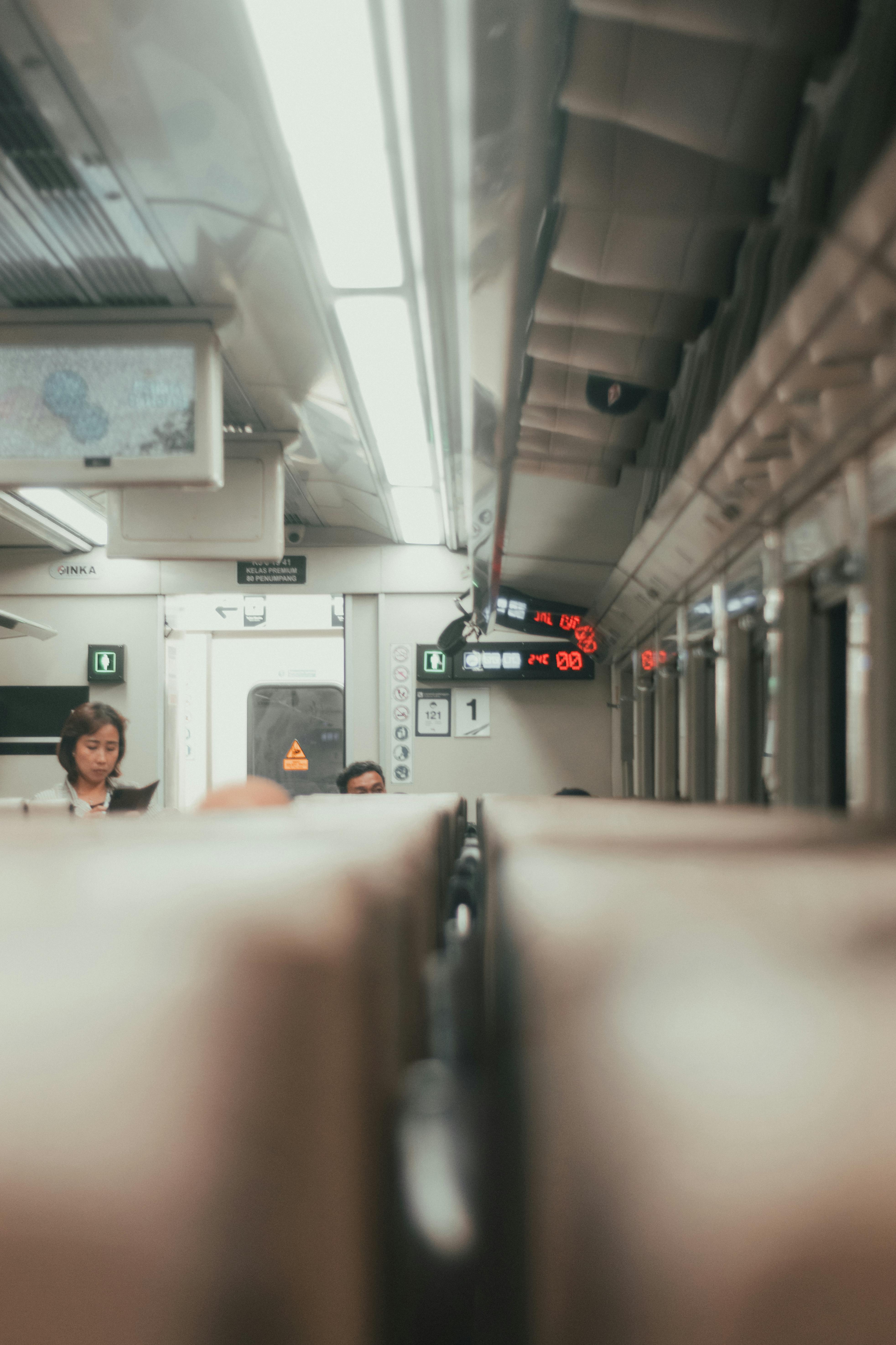 Free Interior view of a train cabin in Jakarta with commuters. Quiet and focused atmosphere on a journey. Stock Photo