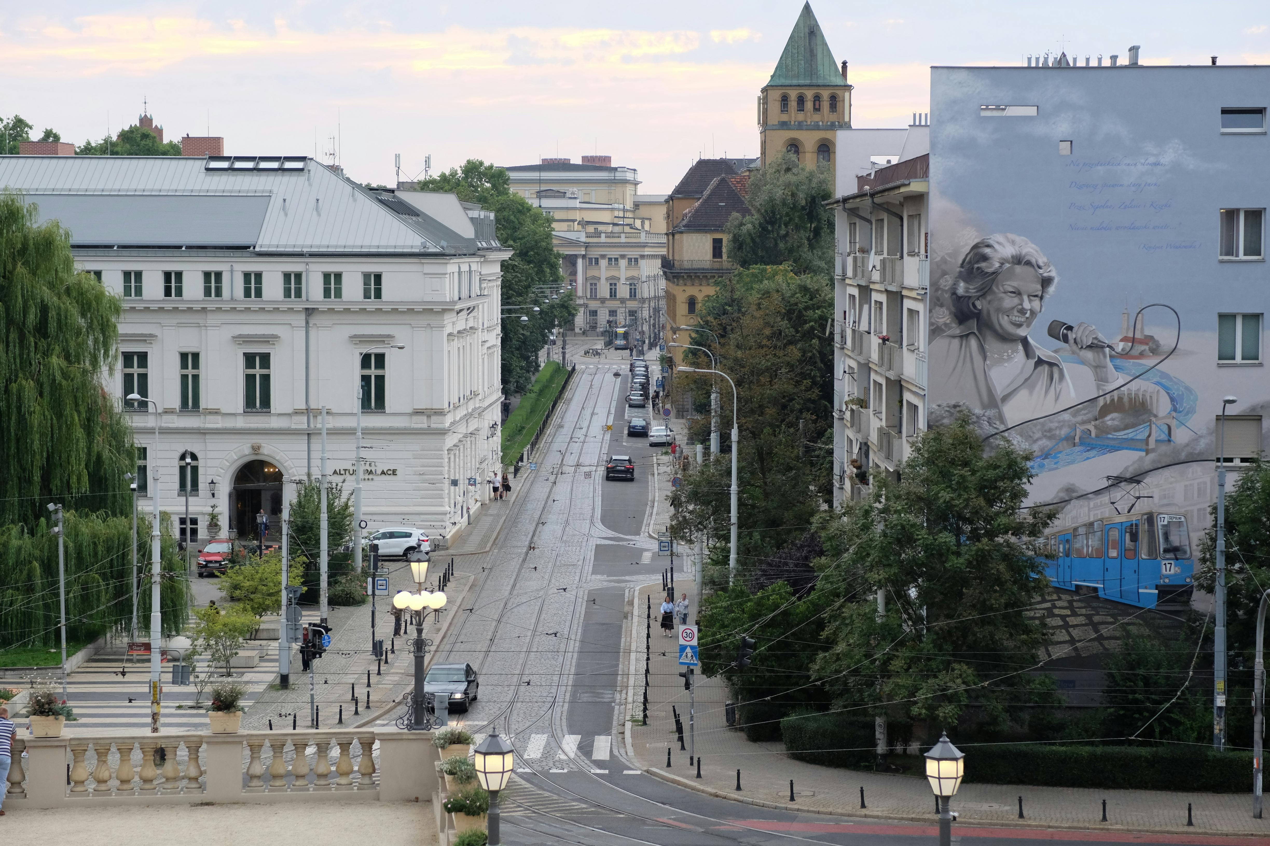 Urban scene featuring a historical street and a mural in a vibrant city.
