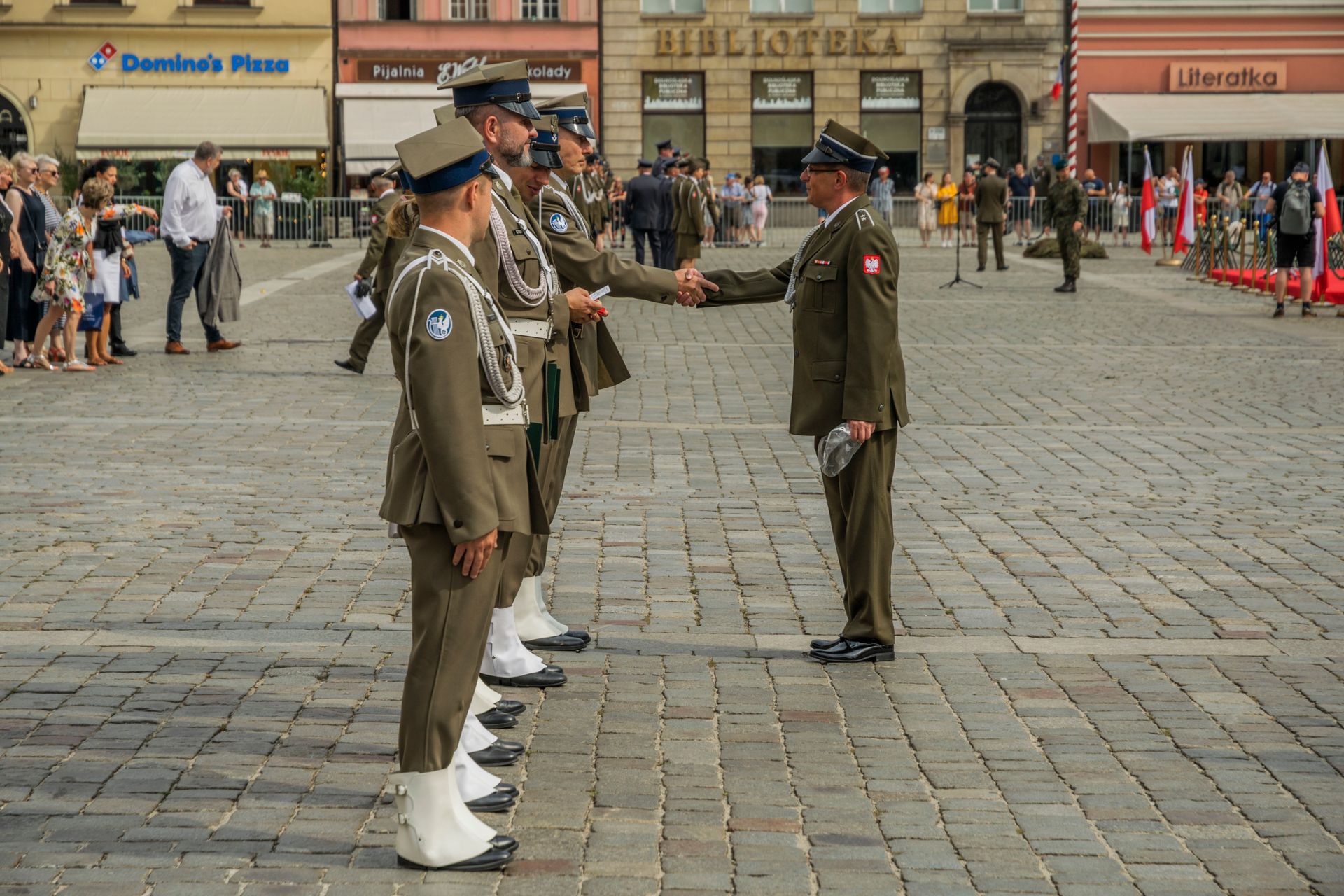 Polish military personnel in uniform during a ceremonial event in Wrocław's Market Square.