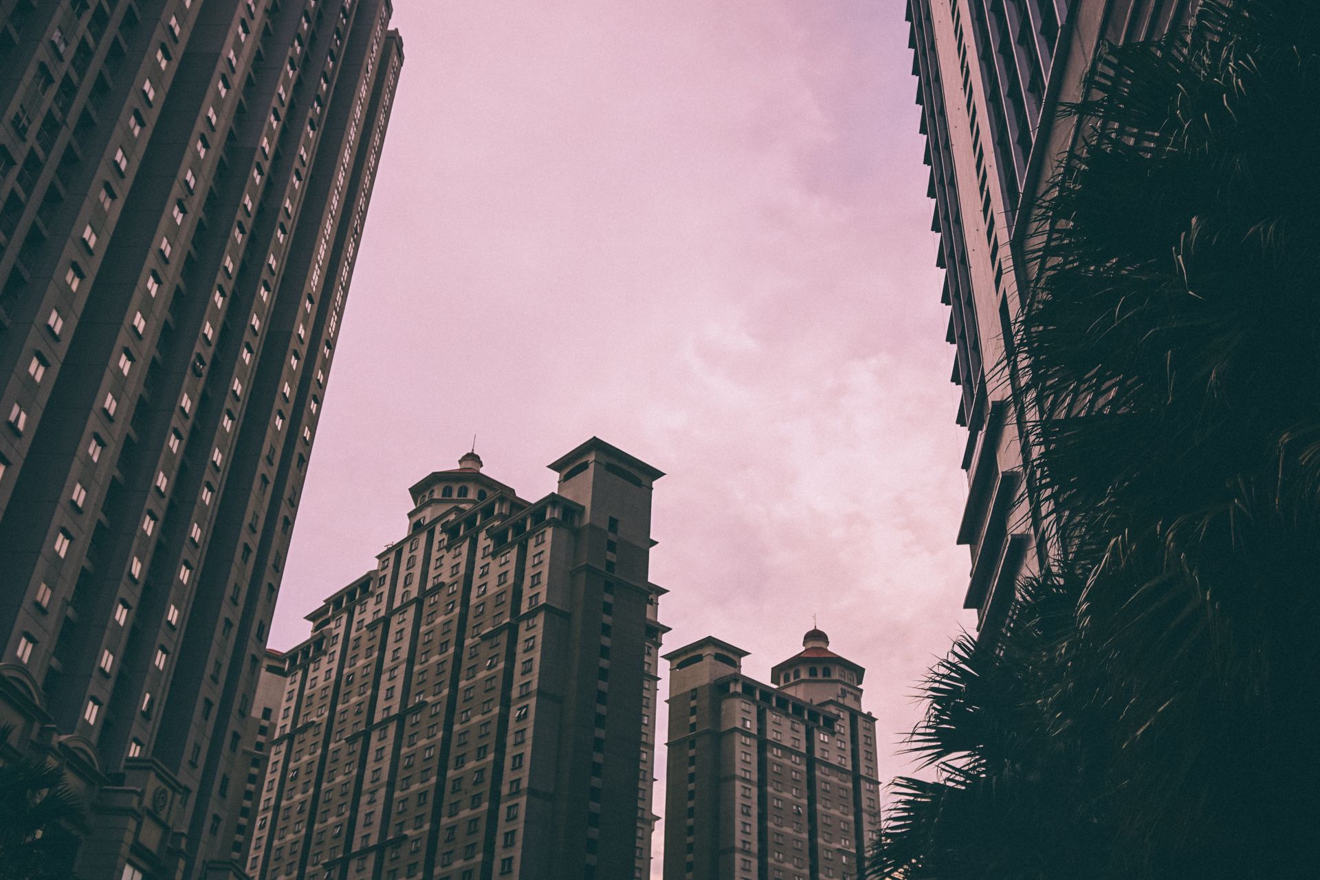 Stunning view of Jakarta skyline with tall modern buildings against a pink sunset sky.