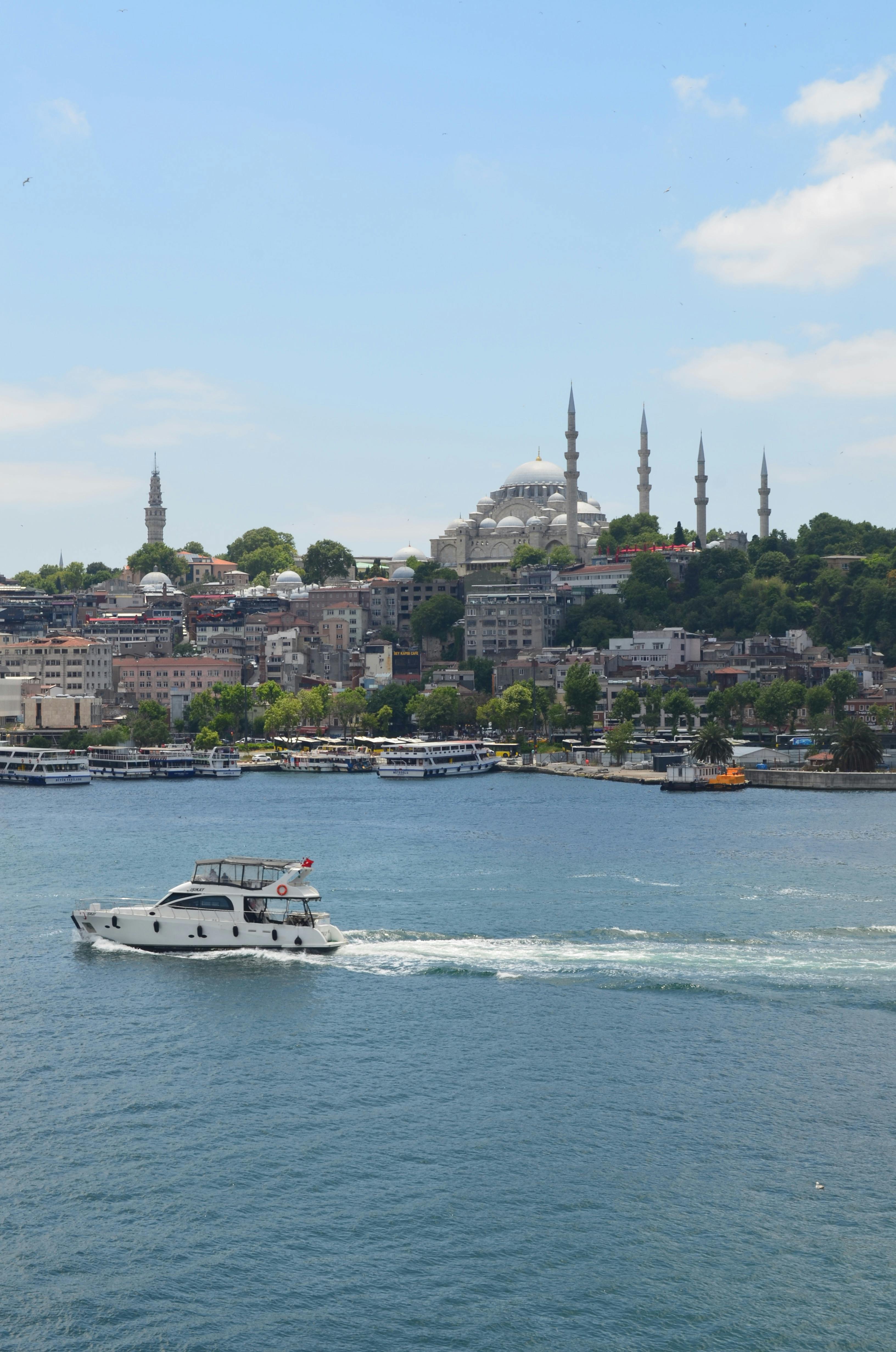 a boat traveling through the water near a city