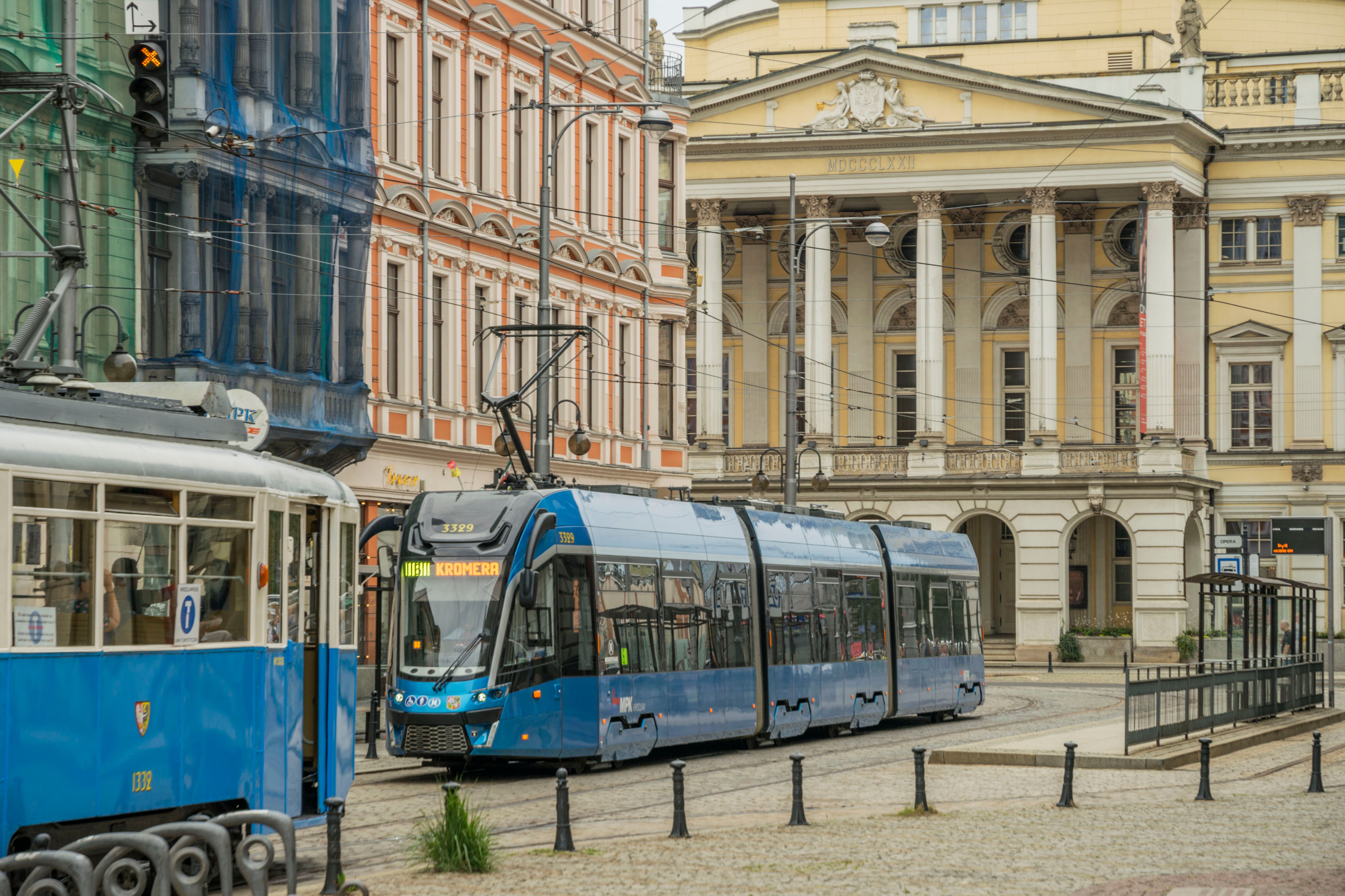 A modern ZTM tram moving through a street in Warsaw, Poland.