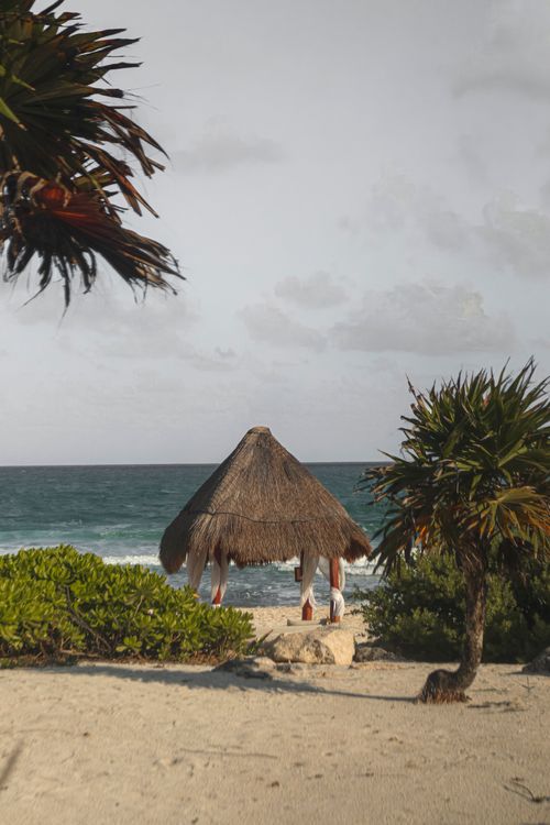 Free Serene beach scene with a thatched hut in Cancún, Mexico. Perfect vacation spot. Stock Photo