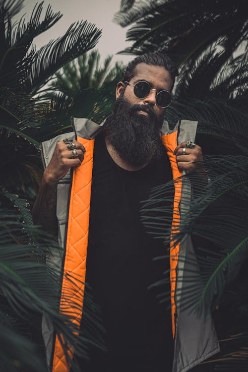 Photo of Man Standing Near Dark Green Plants