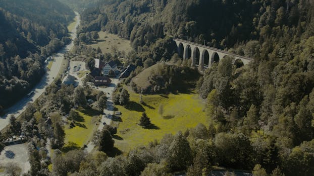 Scenic aerial view of a historical railway bridge amidst lush greenery in Breitnau, Germany.