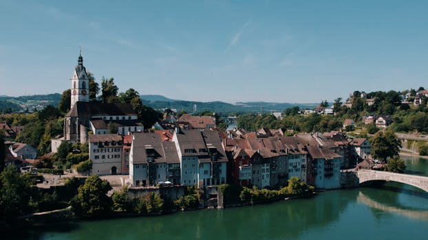 Aerial view of historic Laufenburg, Switzerland, featuring architectural charm along the Rhine River under a clear summer sky.