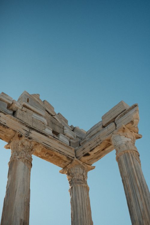 Free Close-up of ancient Greek temple columns against a clear blue sky, capturing historical architecture. Stock Photo