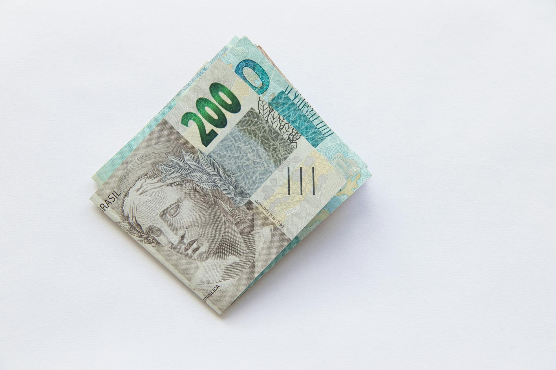 Stack of 200 Brazilian Real banknotes isolated on a white surface, symbolizing wealth and finance.