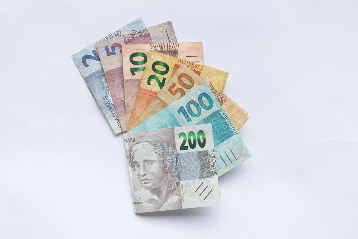 Diversas notas de real organizadas sobre um fundo claro