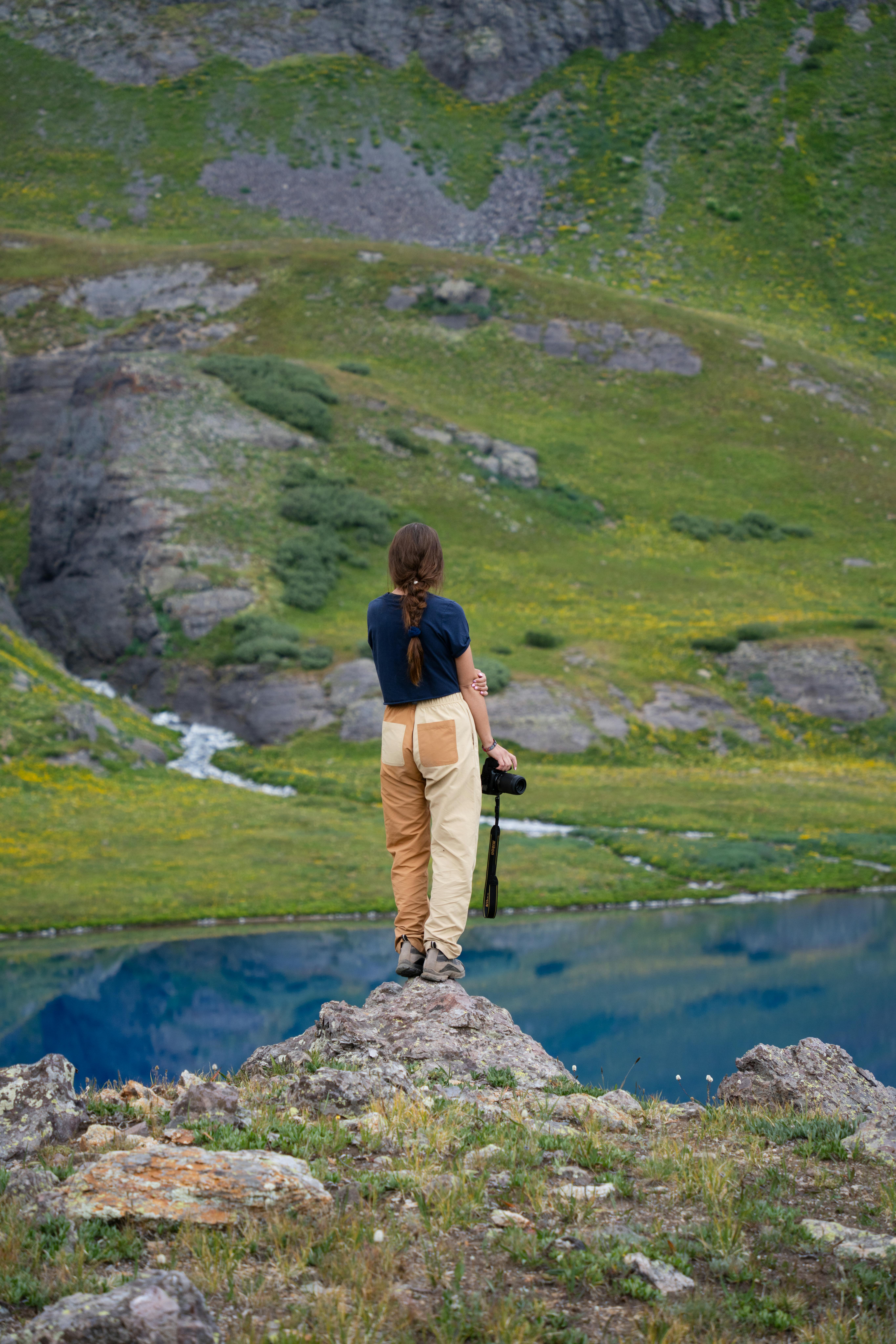 Woman hiker overlooking a tranquil mountain lake, capturing the beauty of nature.