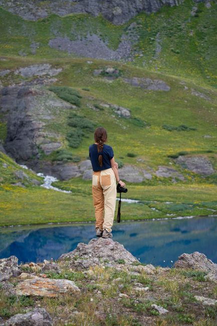 Woman hiker overlooking a tranquil mountain lake, capturing the beauty of nature.