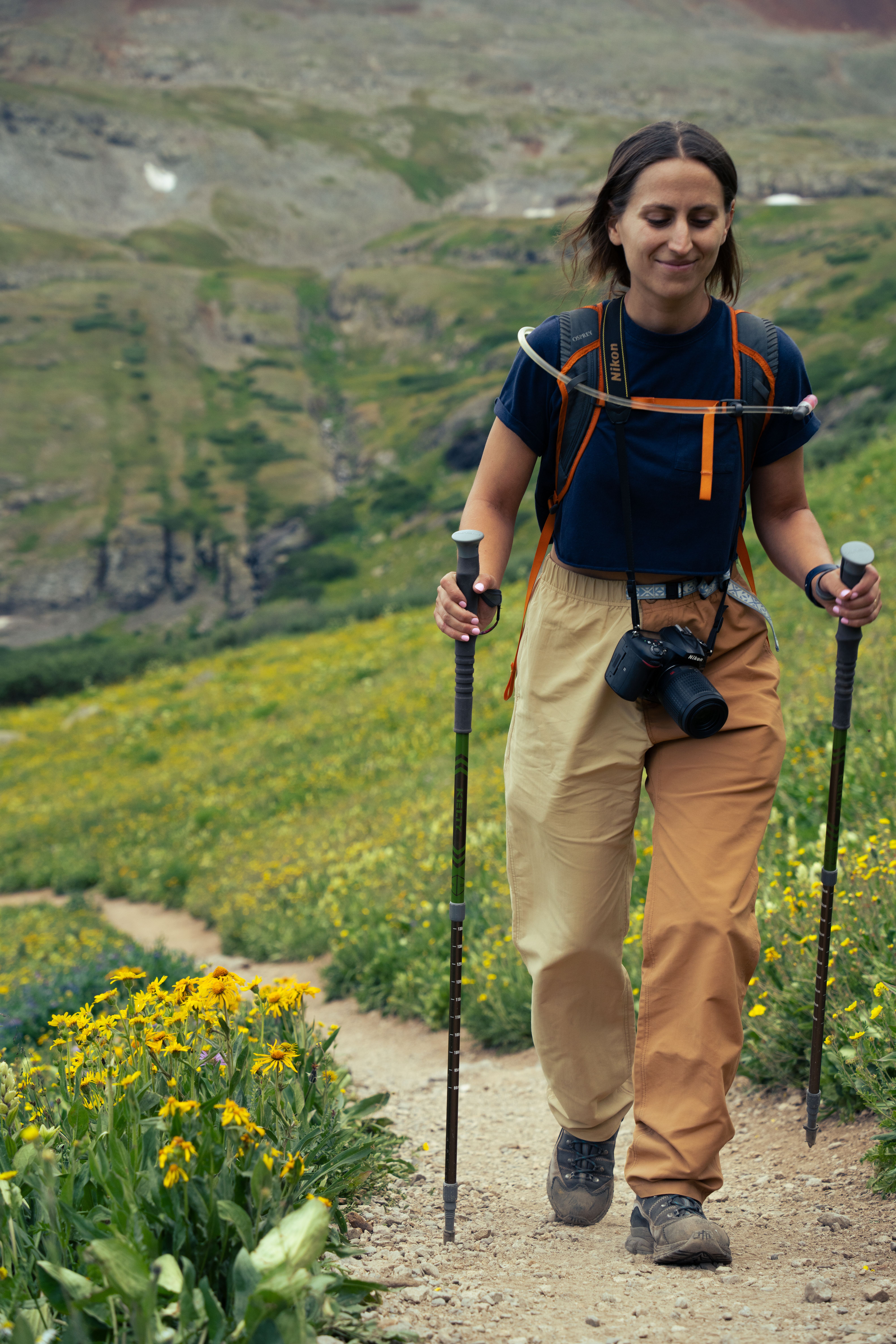 A woman walking on a trail with hiking poles · Free Stock Photo