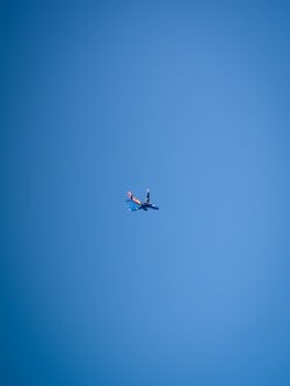 A commercial airplane travels through the clear blue sky, showcasing modern transportation.