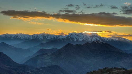 Free Capture the breathtaking view of a snow-capped mountain range at sunrise. Stock Photo