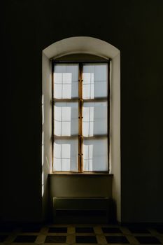 A serene arched window with soft light streaming through, creating gentle reflections.
