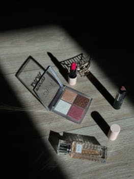 A stylish makeup set with lipstick, eyeshadow, and perfume on wood surface in Amsterdam