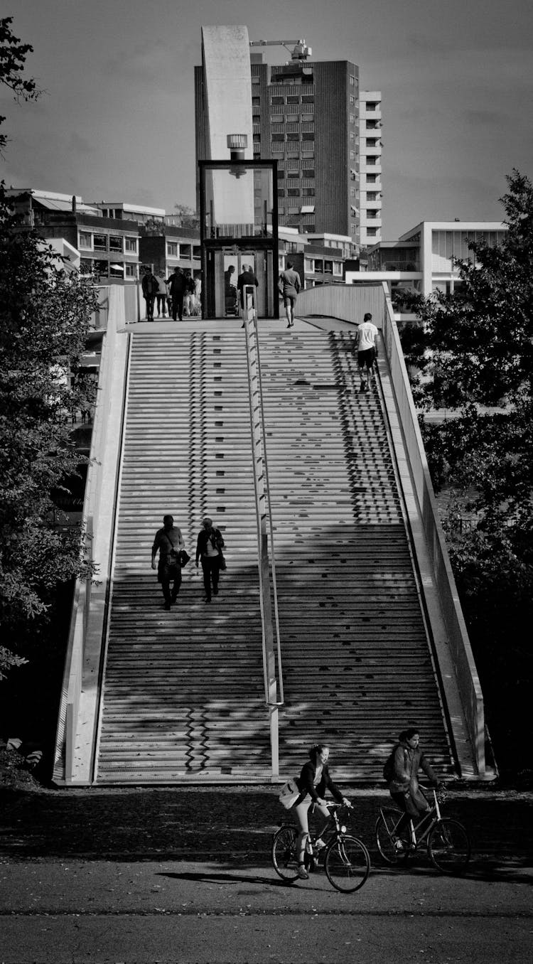 Grayscale Photography Of People Walking On Stairs