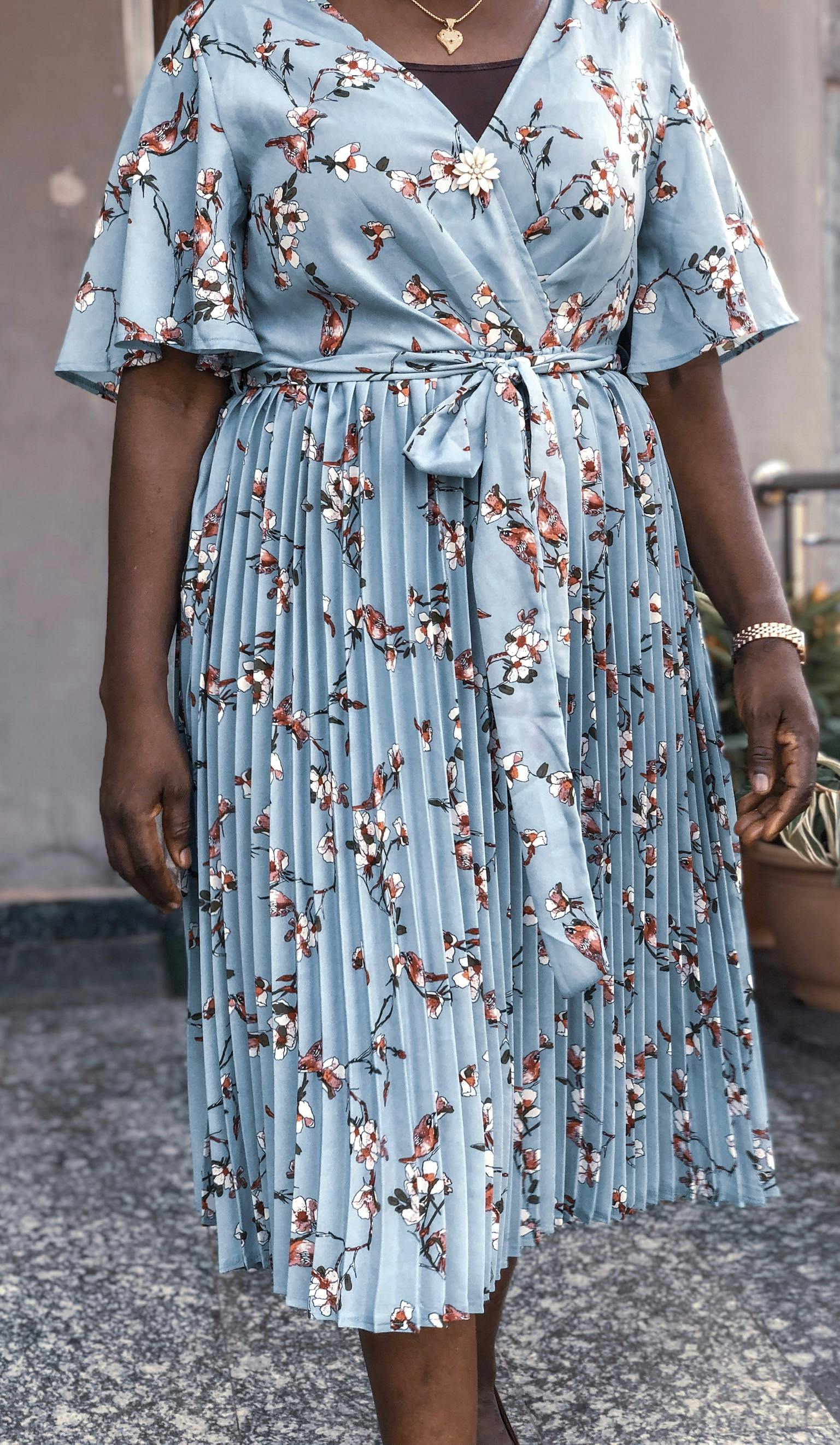 特写一位身着花卉连衣裙的女子，展现时尚与风格