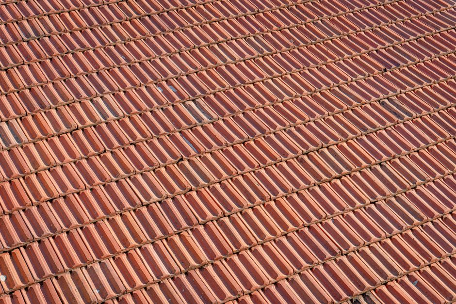 Aerial view of a textured red clay tile roof with a repeating pattern.