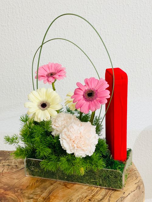 Free A stunning floral arrangement featuring pink and white gerbera daisies and carnations with decorative greenery. Stock Photo
