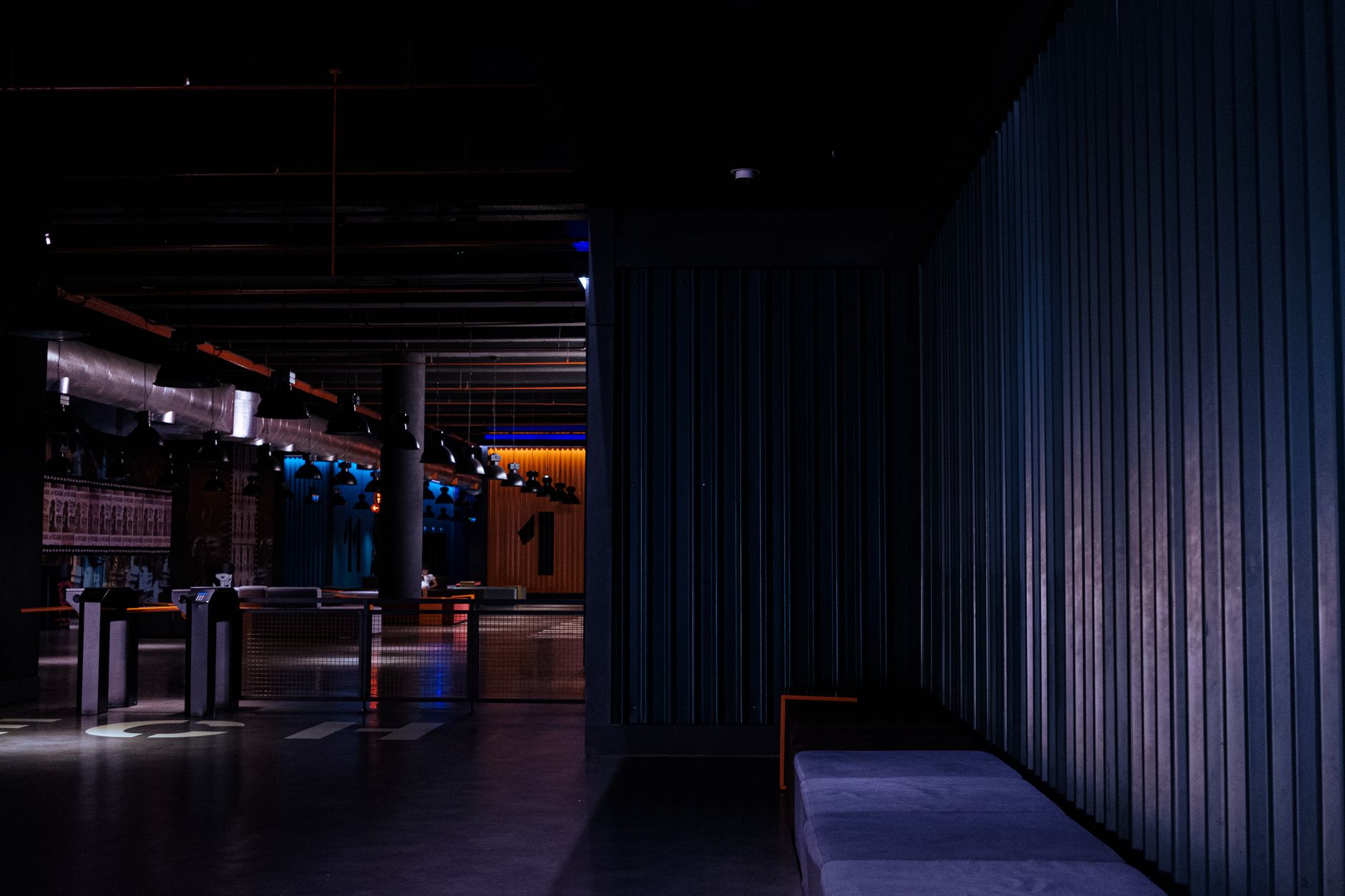 a dimly lit casino lobby with digital game screens, cautious visitor checking terms on smartphone