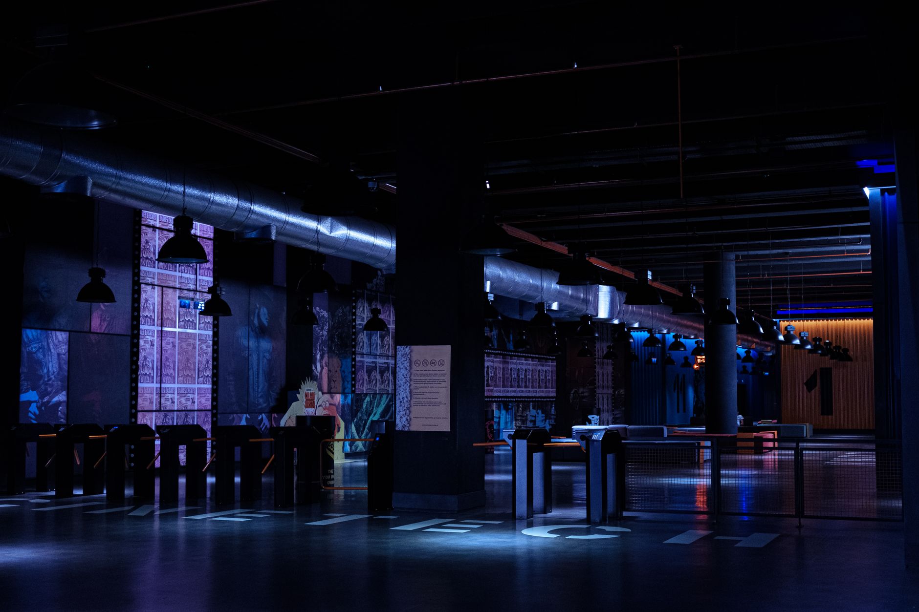 Dimly lit modern venue with industrial design elements and vibrant lighting.