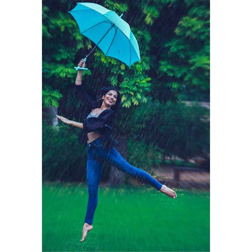 Woman Jumping While Holding Umbrella