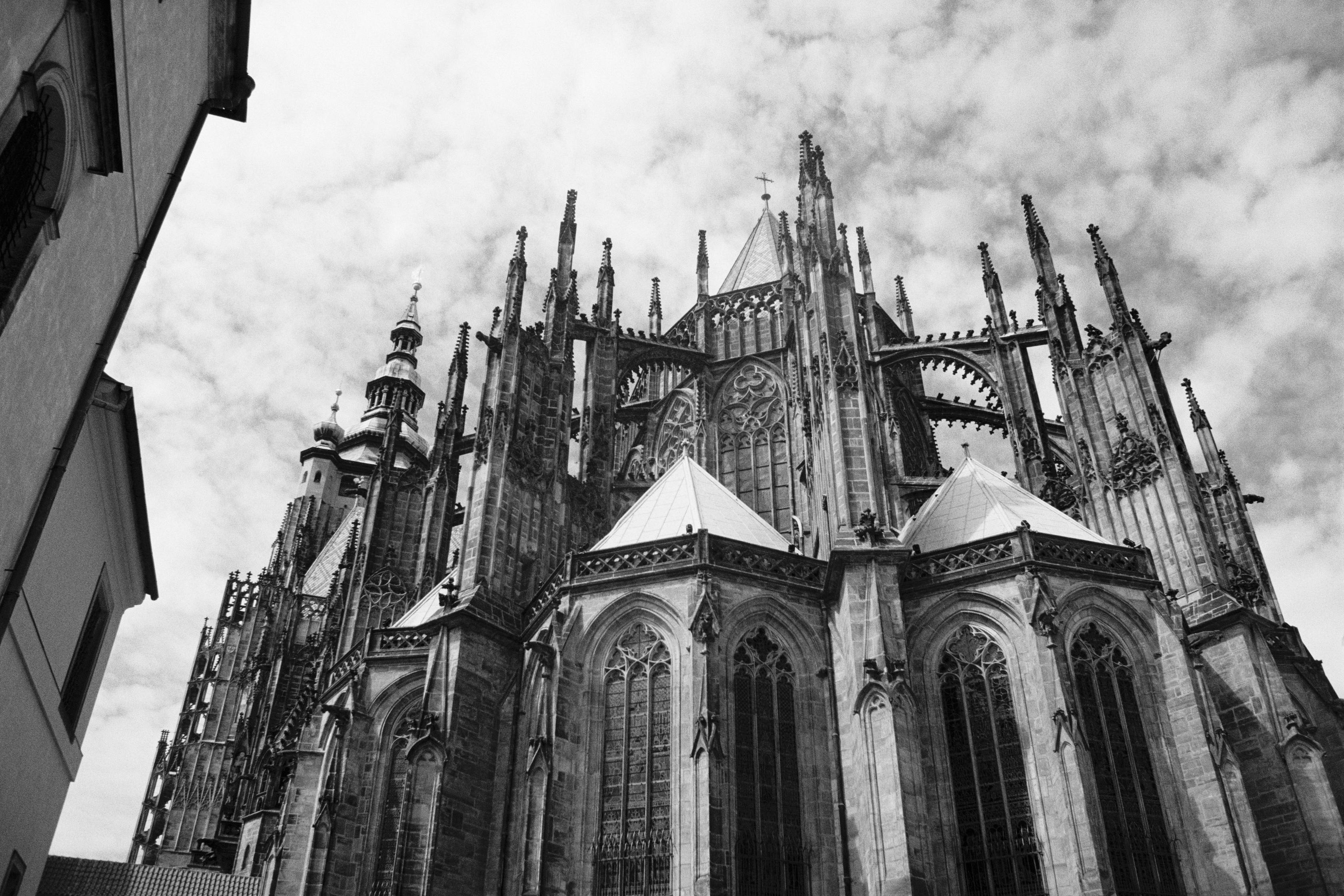 Stunning black and white photograph of a Gothic cathedral, showcasing its intricate architecture and towering spires against a cloudy sky.