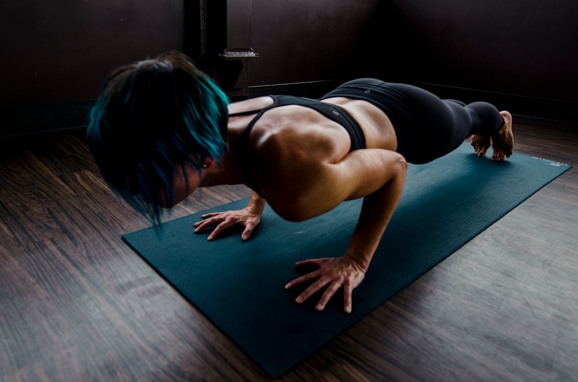 A woman doing pushups on a matt