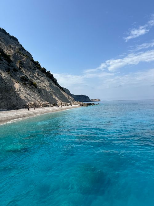 Free Breathtaking view of Lefkada's turquoise beach backed by rocky cliffs, perfect for summer relaxation. Stock Photo