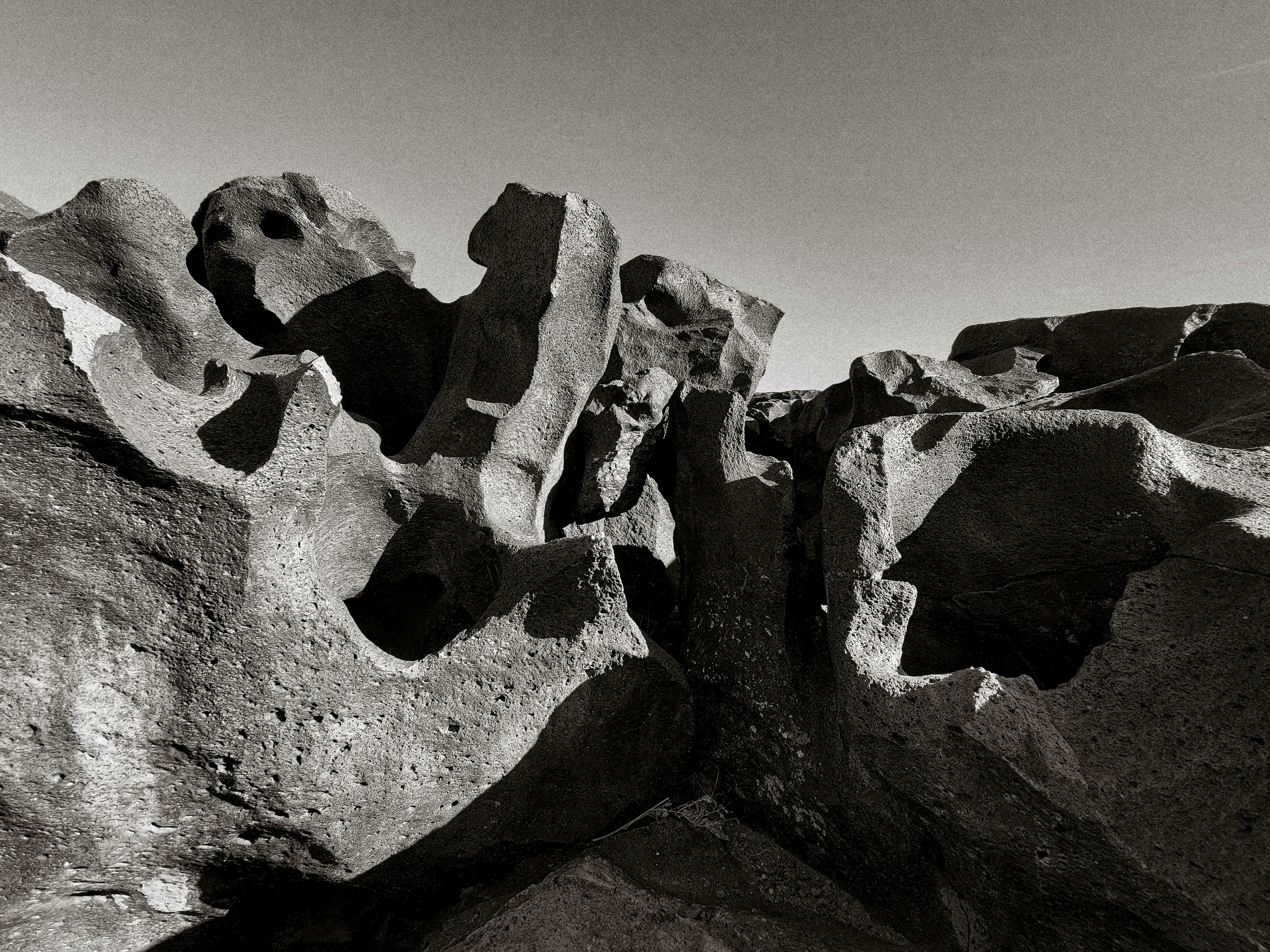 Monochrome image of unique eroded rock formations in an outdoor landscape.