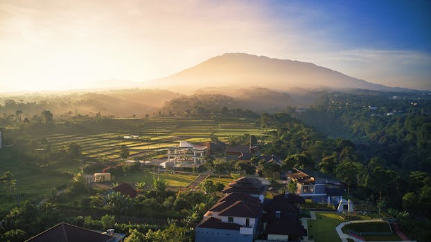 A breathtaking aerial view of sunrise over the hills and rice fields in West Java, Indonesia.