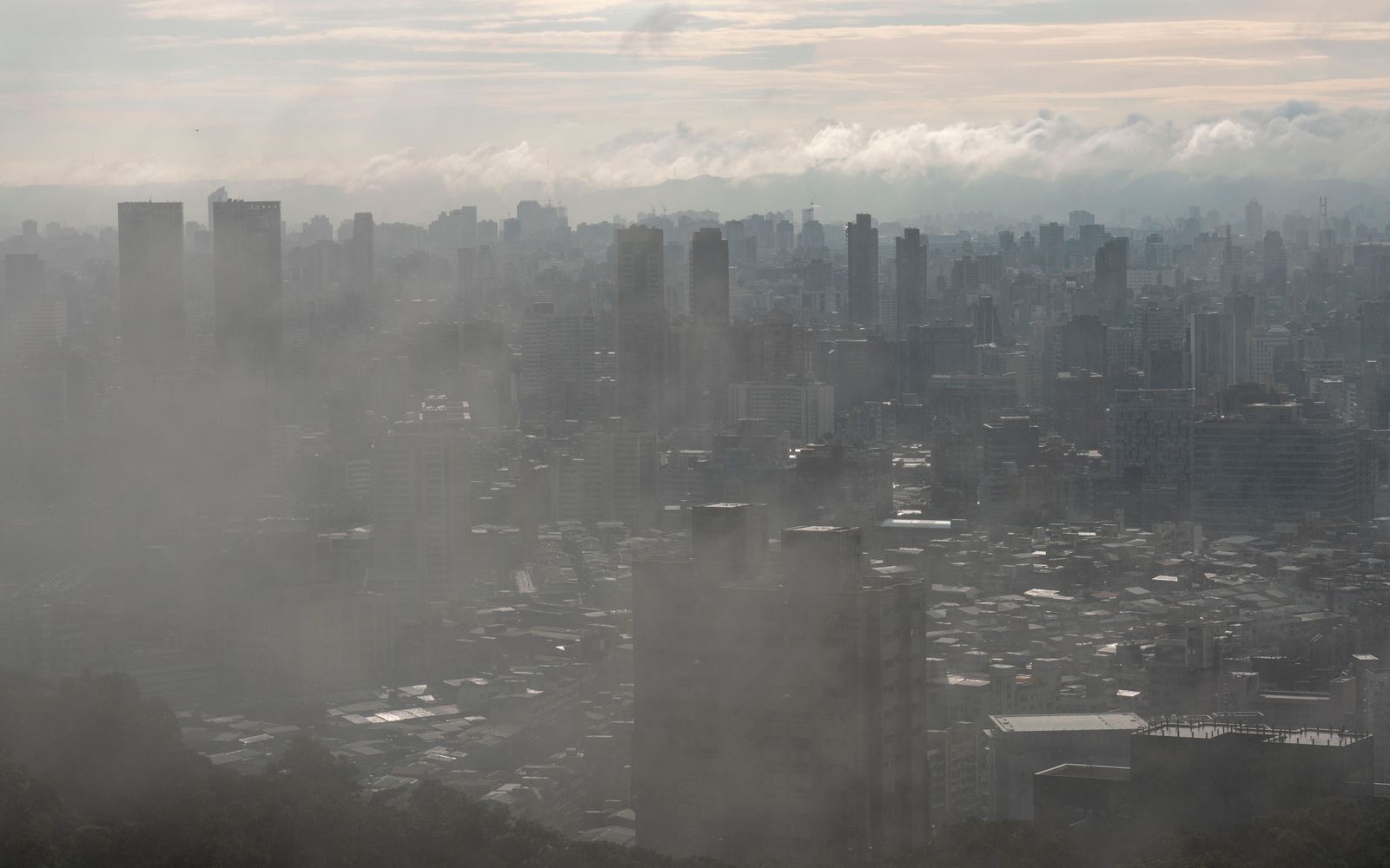 A city skyline seen from above, shrouded in haze