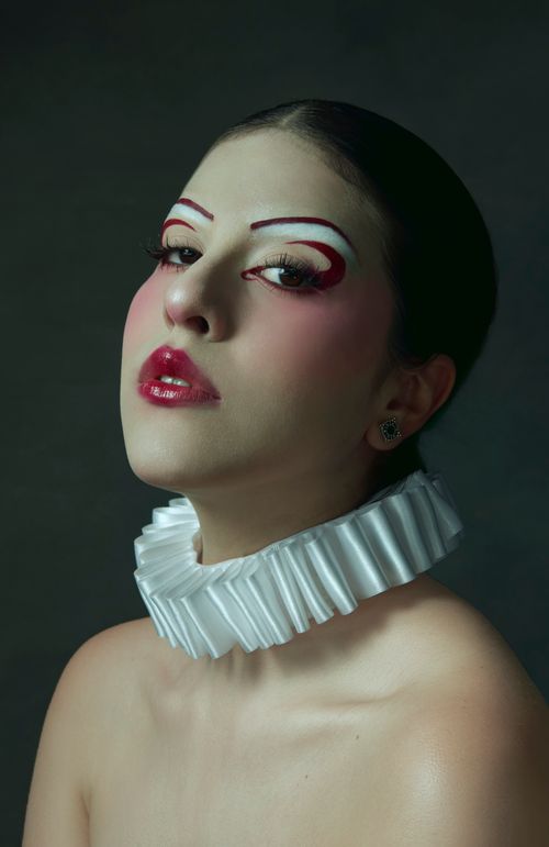 Free Possess an intriguing fashion moment with this striking studio portrait of a model with bold makeup and a statement collar. Stock Photo