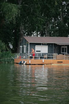 A peaceful scene of a houseboat on a serene river with lush greenery in Hungary.