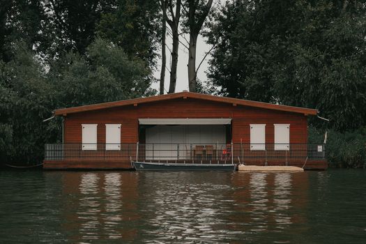 Serene boathouse on a calm lake in Hungary surrounded by lush greenery.