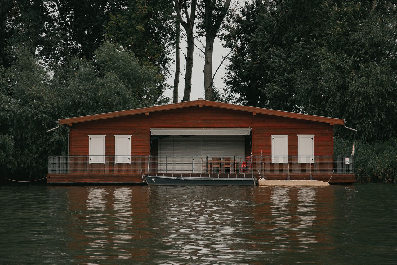 serene boathouse on a calm lake in hungary surrounded by lush greenery