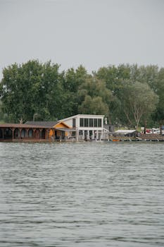 Charming lakeside house in Hungary surrounded by lush trees, ideal for serene reflections.
