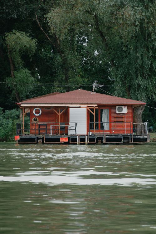 Free Charming lakeside house in Hungary with lush greenery and tranquil water view. Stock Photo