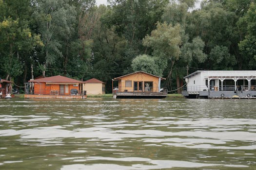 Tranquil scene of floating boathouses on a lake in Hungary surrounded by lush greenery.