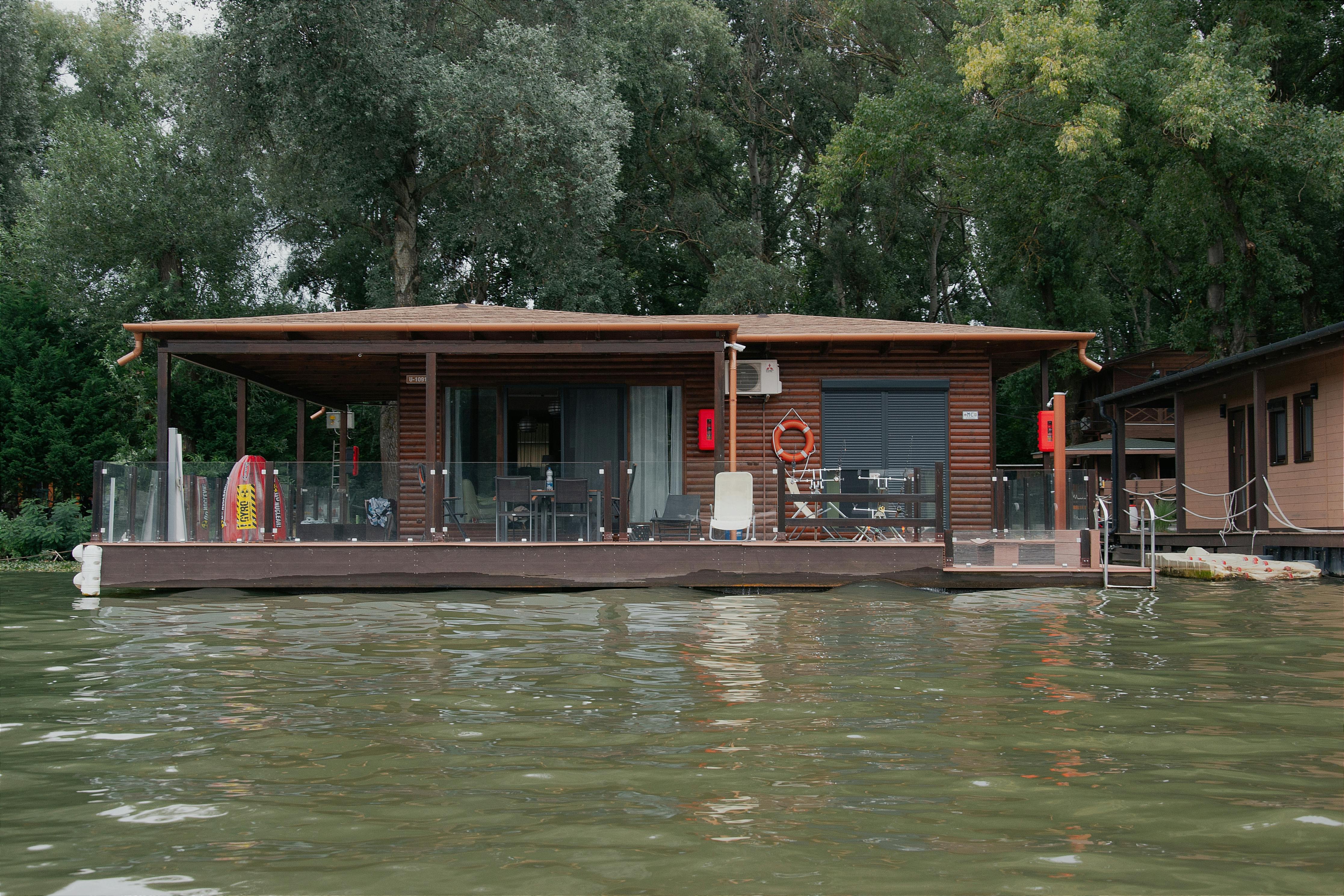 Charming lakefront wooden house surrounded by lush greenery in Hungary.