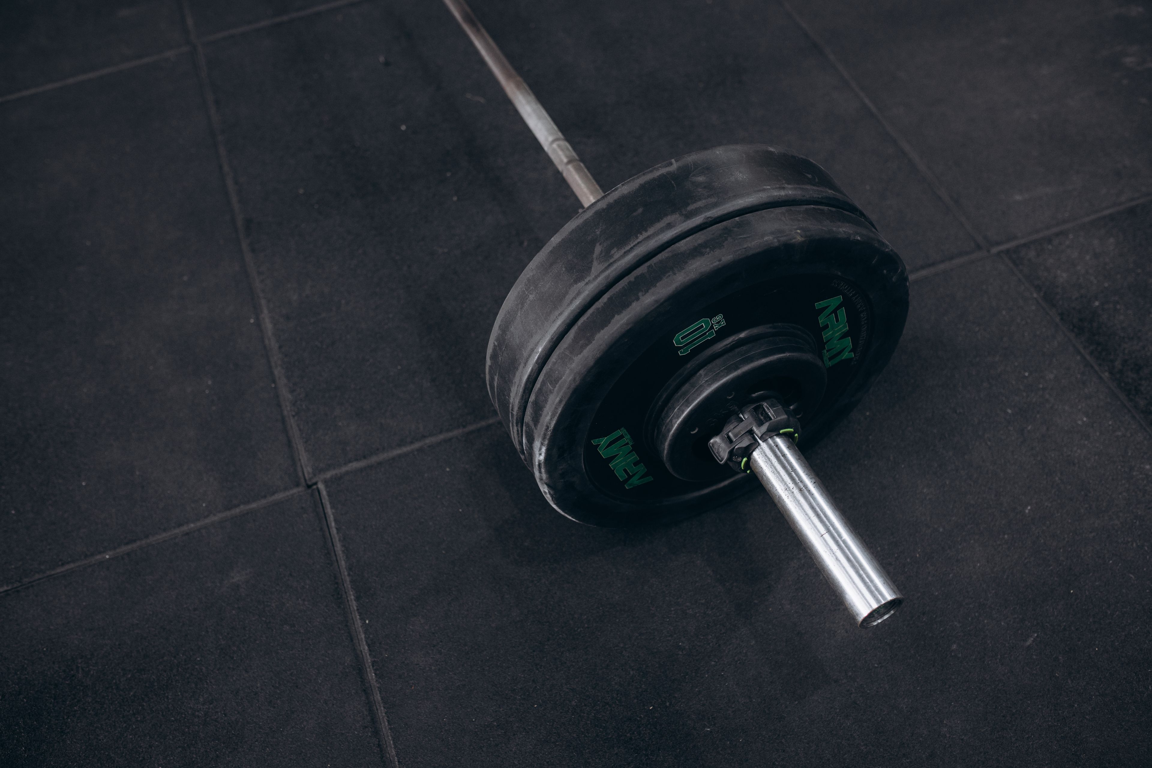 Heavy barbell resting on a gym floor, ideal for strength training visualizations.