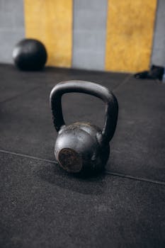 Close-up of a rustic kettlebell on a gym floor, ideal for fitness and workout themes.