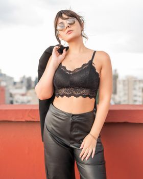 Stylish portrait of a woman in chic attire on a rooftop in Mexico City.