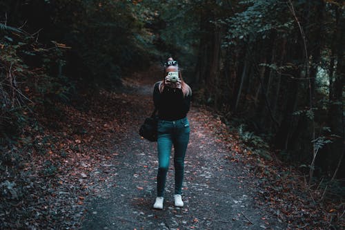 Vrouw Met Behulp Van Camera Terwijl Je Dichtbij Bomen