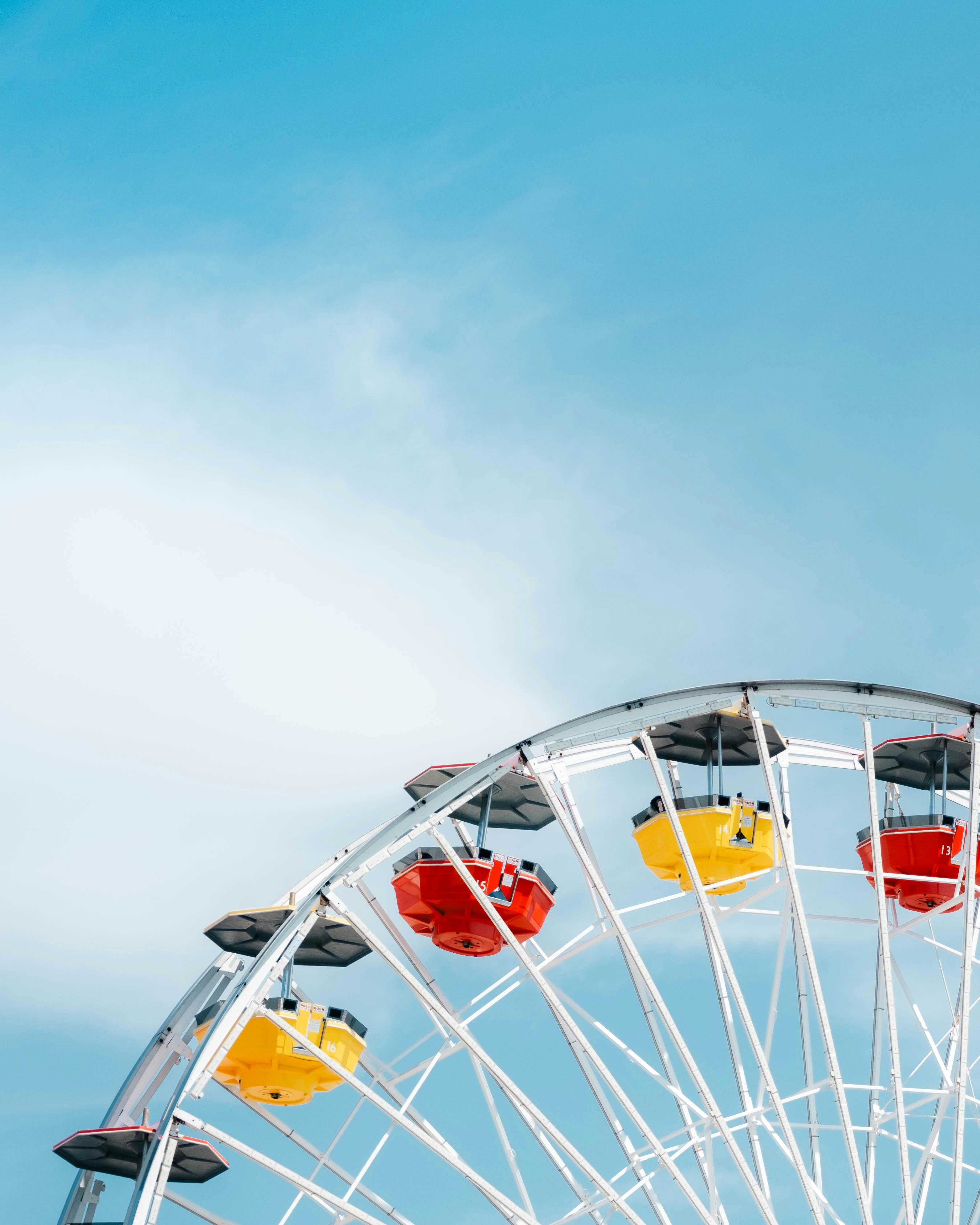Colorful ferris wheel against a bright blue sky at Santa Monica Pier, Los Angeles.