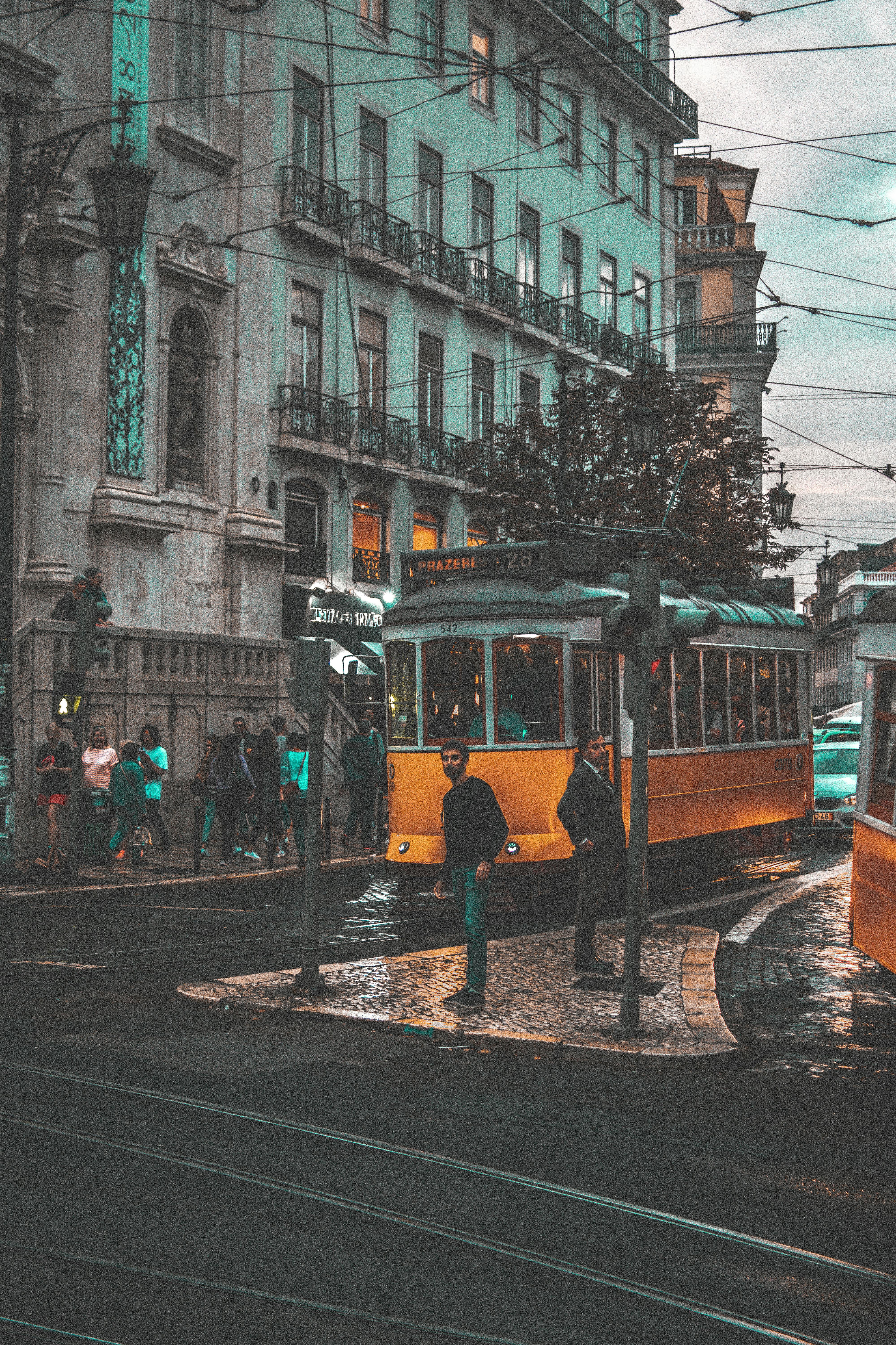 two men standing near yellow tram