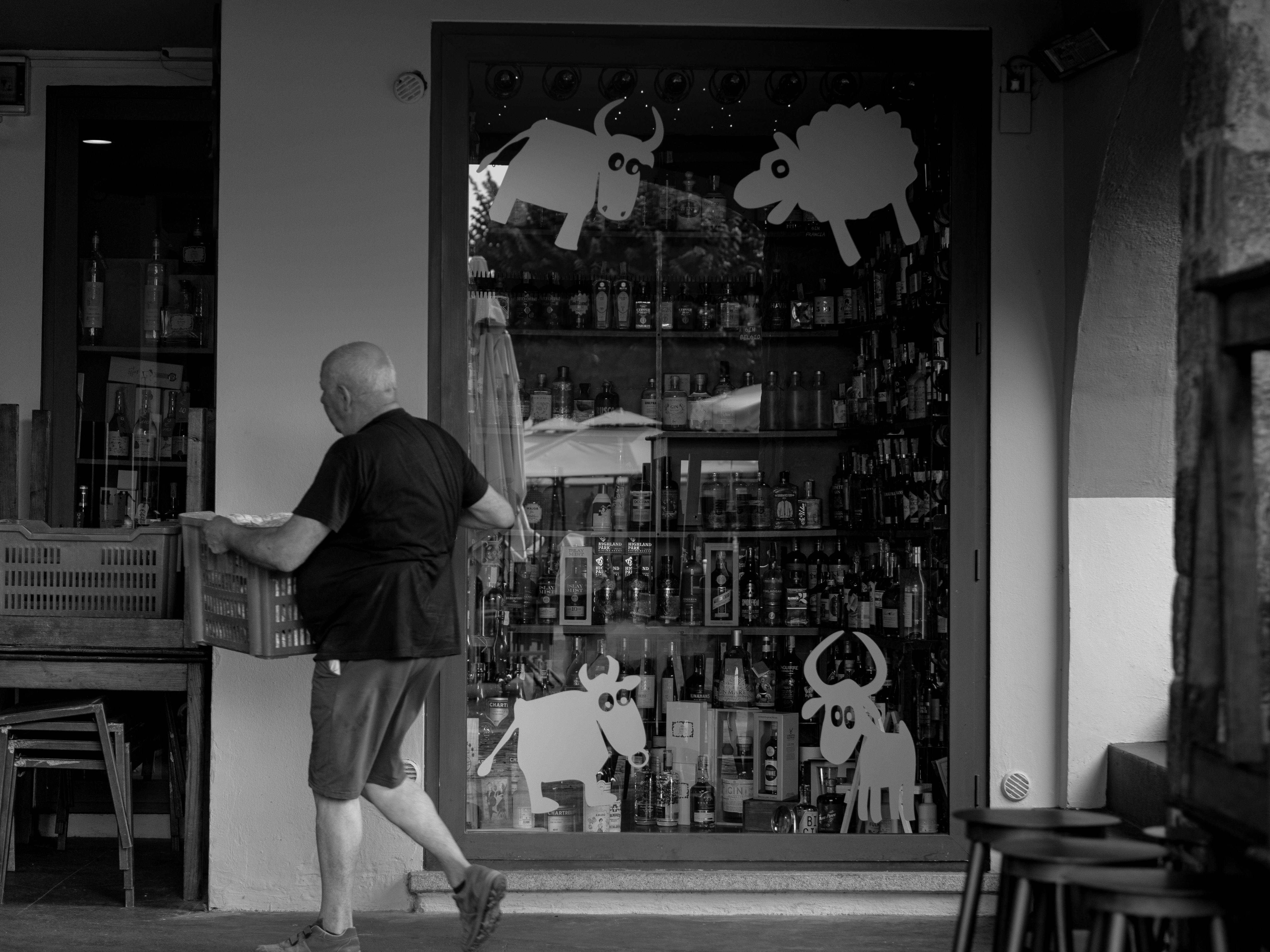 a man walking past a store with a sign that says the best beer in town